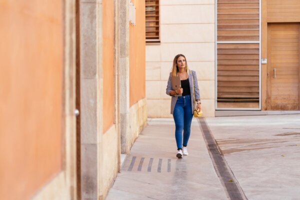Asesoría para autónomos en Granada. Mujer autónoma caminando por la calle.